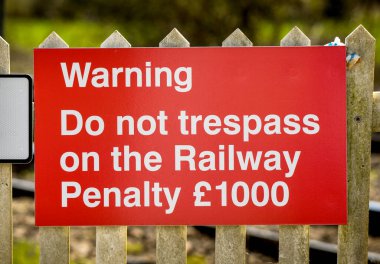 Büyük kırmızı tabela insanları demiryoluna girmemeleri konusunda uyarıyor.