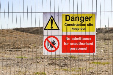 İnşaat alanının etrafındaki tel örgü çitlerinde tehlike işareti var. Kimse yok..