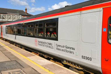 Caerphilly, Wales - Nisan 2021: Caerphilly tren istasyonundaki yeni Ulaşım Renkleri ile bir yolcu treninin yan görüntüsü.