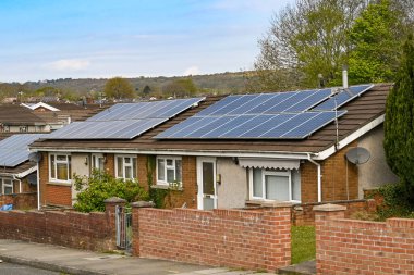 Bridgend, Wales - Nisan 2021: Çatıdaki güneş panelleriyle donatılmış bir çift bungalovun ön görünümü.