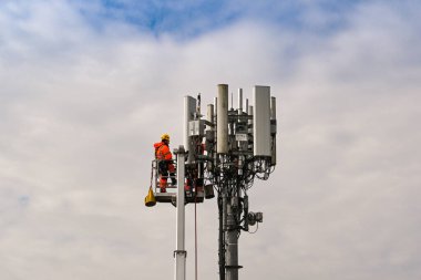 Pencoed, Bridgend, Galler - Nisan 2021: Bakım işleri için cep telefonu direğinin tepesindeki hidrolik platformda mühendis
