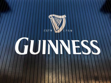 Dublin, İrlanda - Şubat 2018: Dublin 'deki Guinness Bira Fabrikasının ahşap kapılarında logo. Ziyaretçi merkezi şehrin önemli bir turistik merkezidir.
