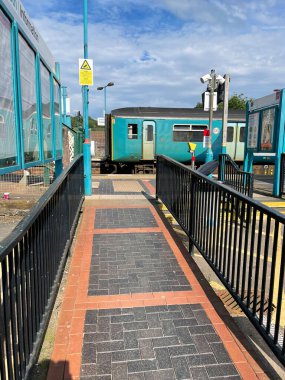 Treforest, Wales - Haziran 2021: Treforest tren istasyonundaki platforma çıkan patika. Arka planda bir tren var..