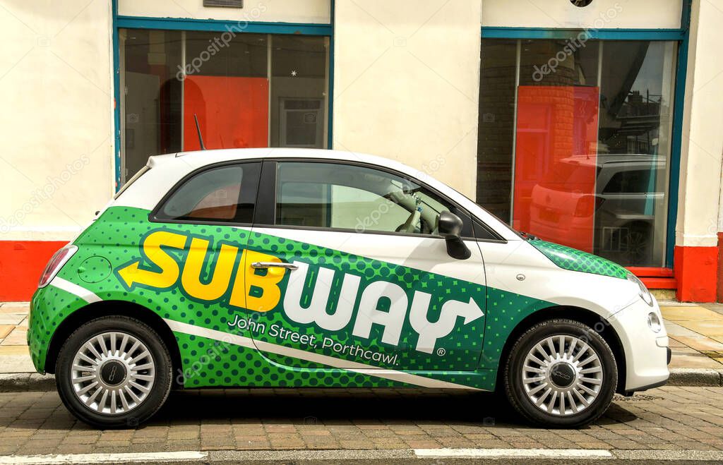 Porthcawl, Wales - June 2018: Small car painted in the coportate colours of the Subway fast food chain to promote a local outlet
