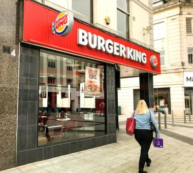 Cardiff, Galler - Haziran 2018: Cardiff şehir merkezinde Burger King 'in bir şubesinin önünden geçen kişi
