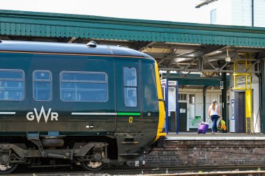 Didcot, İngiltere - Haziran 2021: Didcot tren istasyonuna vardıktan sonra tekerlekli bavul taşıyan yolcu.