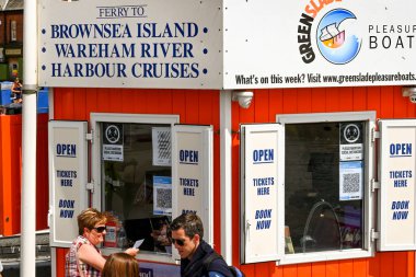 Poole, İngiltere - Haziran 2021: İnsanlar liman ve körfez etrafında tekne gezisi için bilet alıyorlar