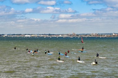 Poole, İngiltere - Haziran 2021: Poole limanında dalgalı suda kürek çekmeyi öğrenen bir grup insan.