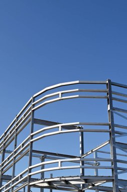 Mavi gökyüzüne karşı çok katlı yeni bir ticari binanın çelik iskeleti. Kimse yok..