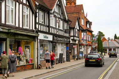 Lyndhurst, Hampshire, İngiltere - Haziran 2021: İnsanlar New Forest 'taki küçük Lyndhusrt kasabasında ana cadde boyunca yürürken dükkanlara bakıyorlar.