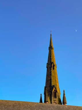 Chester, Cheshire, İngiltere - Temmuz 2021: Alacakaranlıkta Chester 'daki bir kilisenin kalesi sağında ay olan mavi bir gökyüzüne karşı. Uzayı kopyala Kimse yok...