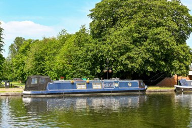 Newbury, Berkshire, İngiltere - Haziran 2021: Tekne, Newbury 'nin merkezindeki Kennet ve Avon Kanalı' nda halka açık bir parka demirlemiş..