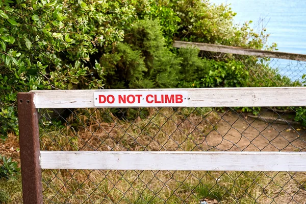 不要爬上悬崖附近的木栅栏上的告示 没有人 — 图库照片
