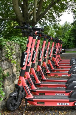 Bath, İngiltere - Ağustos 2021: Şehirdeki bir scooter paylaşım sisteminin bir parçası olarak üst üste kiralık olarak park edilen elektronik e-scooterlar