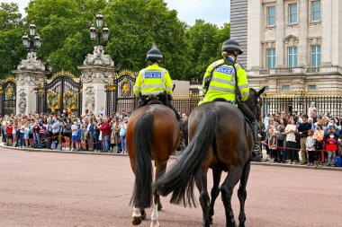 Londra, İngiltere - Ağustos 2021: Buckingham Sarayı 'nın dışında nöbet değiştiren iki polis memuru.
