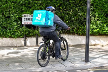 Londra, İngiltere - Ağustos 2021: Deliveroo için çalışan kişi bisiklete binerek bir emir getiriyor