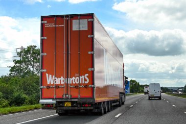Swindon, İngiltere - Haziran 2021: Ekmek üreticisi Warburtons tarafından işletilen ve M4 otoyolunda giden eklemli kamyon.