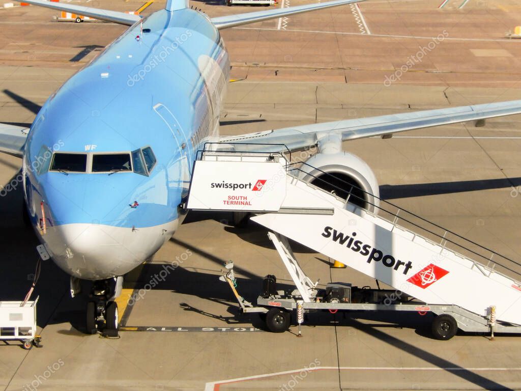 Birmingham, England - September 2021: Passenger steps attached to a Boeing 737 holiday jet operated by TUI, The ground handling equipment is porivded by Swissport.