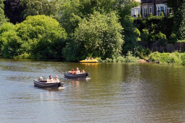 Chester, İngiltere - Temmuz 2021: Şehir merkezi yakınlarındaki Dee Nehri 'nde küçük motorlu teknelerde yaşayan insanlar