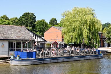 Chester, İngiltere - Temmuz 2021: Chester 'daki Dee nehrinin kıyısındaki bir bar ve restoranın terasında insanlar.