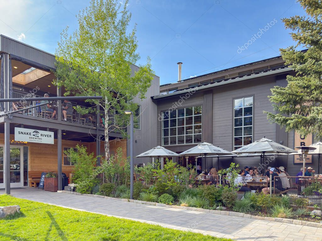 Jackson Hole, Wyoming, USA - 27 May 2025: Exterior view of the entrance and outdoor dining area of the Snake River Brewing brewery in downtown Jackson.