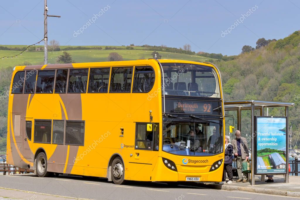 Dartmouth, Devon, England, UK - 24 April 2025: People getting on a double decker service bus operated by Stagecoach at a bus stop in Dartmouth town.