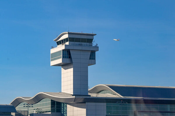 Лос-Анджелес, Калифорния, США - 12 января 2024 года: Контрольная вышка в аэропорту LAX Лос-Анджелеса. На заднем плане взлетает самолет.