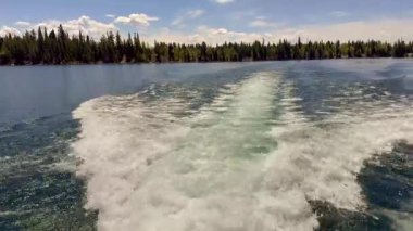 Grand Teton Ulusal Parkı 'nda Jenny Gölü' nden geçen hızlı bir tekneden uyan. Kimse yok..