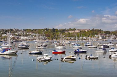 Dartmouth, Devon, İngiltere, İngiltere - 24 Nisan 2025: Limana demirlemiş tekne ve yatların manzarası. Arka planda Kraliyet Donanma Koleji var..