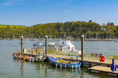 Dartmouth, Devon, İngiltere, İngiltere - 24 Nisan 2025: Küçük yolcu feribotu Dartmouth 'taki nehir dartında bir iskelenin yanında demirli..