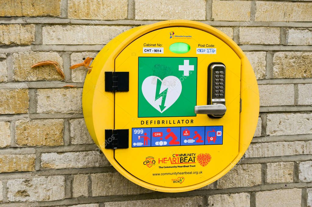 Woodstock, Oxfordshire, England, UK - 8 October 2025: Automatic AED defibrillator for public use in the event of an emergency on the wall of a shop in the town of Woodtsock