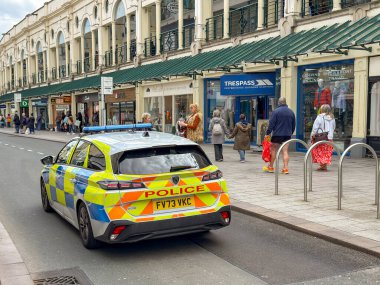 Torquay, Devon, İngiltere, İngiltere - 23 Nisan 2025: Devon ve Cornwall Polisi 'nin polis aracı Torquay şehir merkezindeki ana alışveriş caddesi boyunca ilerliyor.