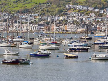 Dartmouth, Devon, İngiltere, İngiltere - 24 Nisan 2025: Arka planda Dartmouth kasabası bulunan Dart Nehri 'ndeki tekne ve yatların manzarası