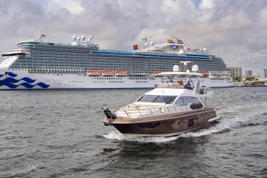 Fort Lauderdale, Florida, ABD - 2 Aralık 2023: Fort Lauderdale limanında yolcu gemisinin önünden geçen lüks bir motorlu tekne yolcuları.
