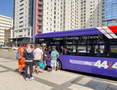Cardiff, Wales, İngiltere - 15 Ağustos 2025: Cardiff şehir merkezinde halk otobüsüne binen insanlar. Araç Cardiff otobüsü tarafından çalıştırılıyor..