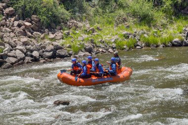 Canon City, Colorado, ABD - 22 Mayıs 2025: İnsanlar Arkansas Nehri 'nde Royal Vadisi' nden akan şişme bir sandalda kürek çekiyor.