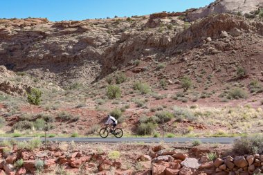 Moab, Utah, ABD - 26 Mayıs 2025: Moab yakınlarındaki bir açık alanda bisiklet yolu üzerinde bisiklet süren kişi.
