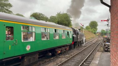 Alton, Hampshire, İngiltere - 20 Temmuz 2025: LMS Ivatt sınıfı buharlı lokomotif 41312 Watercress Hattı 'nda Ropley tren istasyonundan ayrılıyor.