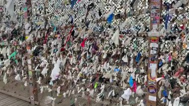 New York City, New York, ABD 11 Ocak 2026: Kurdeleler, kağıt mendil ve saç bantları Brooklyn Köprüsü 'ndeki çitlere bağlı. Sağdan sola dönüyor.