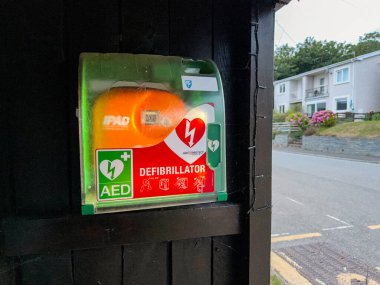 St Dogmaels, Cardiganshire, Galler, İngiltere - 26 Temmuz 2025: Köydeki bir otobüs durağındaki bir konteynırda kalp krizi geçiren hastalara yardım etmek için AED defibrilatör ekipmanı