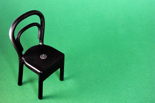 Кнопка на черном пластиковом стуле — стоковое фото