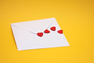 Beyaz bir posta zarfında kırmızı kalpler. Aşk ve Sevgililer Günü kavramı.