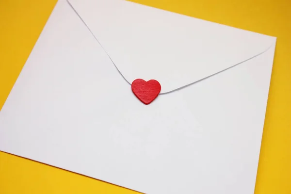 A red heart on a white postal envelope. The concept of love and Valentines Day. — Stock Photo, Image