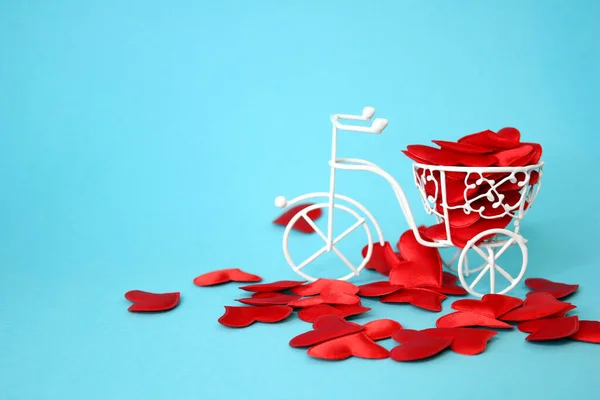 De nombreux cœurs rouges sont animés par un vélo décoratif blanc en fil de fer. Fond bleu. Concept Saint-Valentin. — Photo