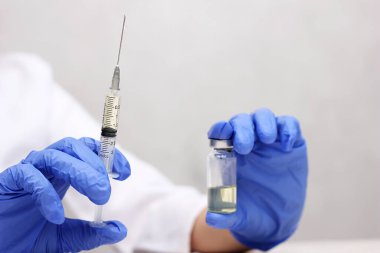 Bir sağlık çalışanı şırınga ve bir şişe aşı taşıyor. Coronavirus. Aşılama. Covid-19 'un önlenmesi. Nüfusun aşılanması, önleyici aşılar. Tedavi