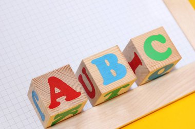 ABC - İngiliz alfabesinin tahta oyuncak blokları üzerindeki ilk harfleri. Yabancı dil öğreniliyor.