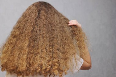 Güzel, güçlü, sağlıklı kadın saçı. Kalın, doğal, uzun dalgalı saçlar. Arkadan bak. Dalgalı saç ve keratin düzleştirme hizmetleri. Kabarık saçlar.