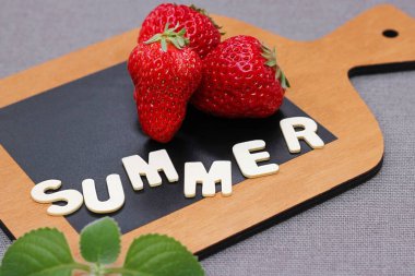 Tahta kesim tahtasının üzerinde, tahtadan harflerle 