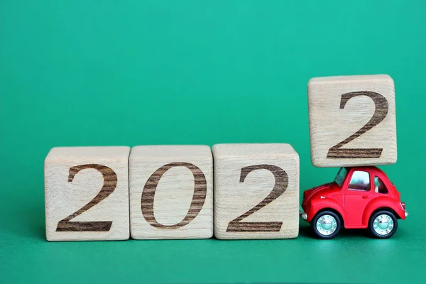 赤いおもちゃの車は番号2022でブロックを運んでいます。2022年が近づいています。新年明けましておめでとう. ストック画像