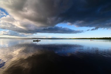 Everglades Ulusal Parkı 'ndaki Coot Bay' de kayakçılar dramatik günbatımı bulutları altında.
